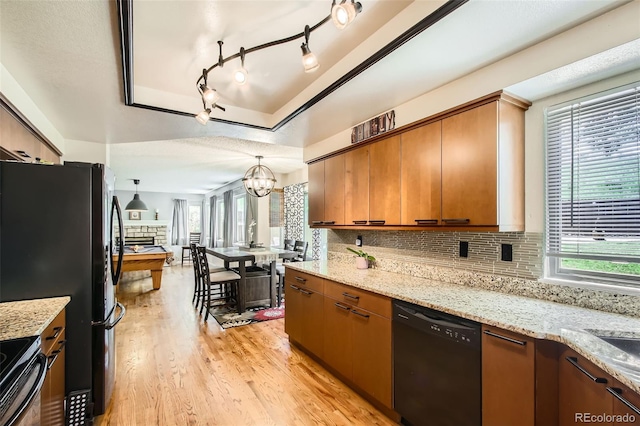 12013 W 56th Cir, Arvada, CO 80002 - kitchen with black appliances, light wood-type flooring, tasteful backsplash, and a chandelier