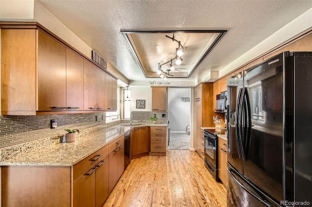 12013 W 56th Cir, Arvada, CO 80002 - kitchen featuring black appliances, a textured ceiling, light wood-style flooring, tasteful backsplash, and brown cabinets
