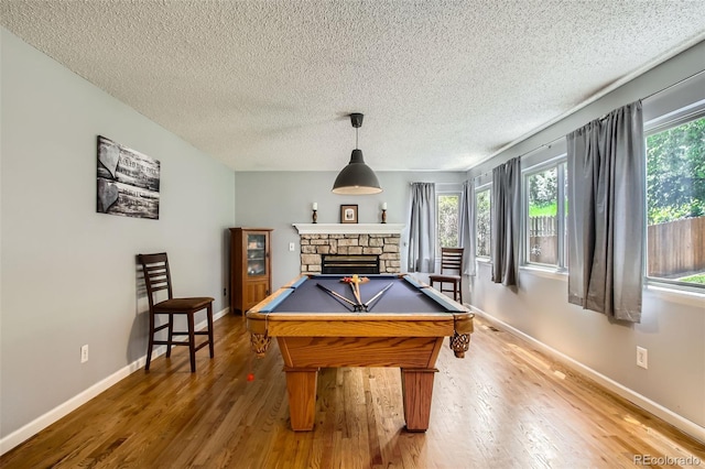 12013 W 56th Cir, Arvada, CO 80002 - game room with wood finished floors, a textured ceiling, a fireplace, and billiards table