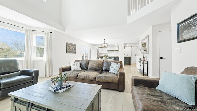 living area with light wood-style floors, a barn door, and a towering ceiling