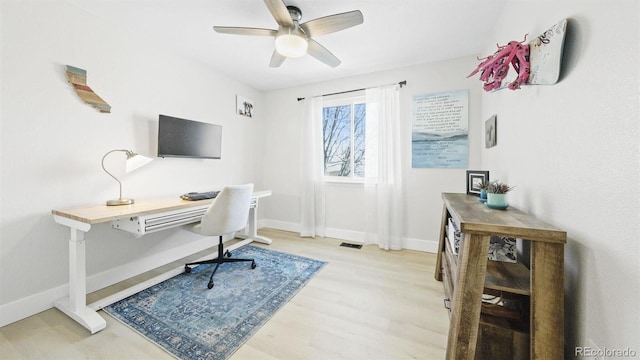 office area with visible vents, ceiling fan, light wood-type flooring, and baseboards