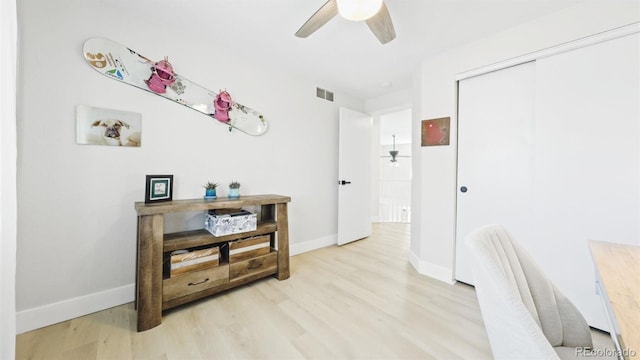 corridor with visible vents, baseboards, and light wood-style floors