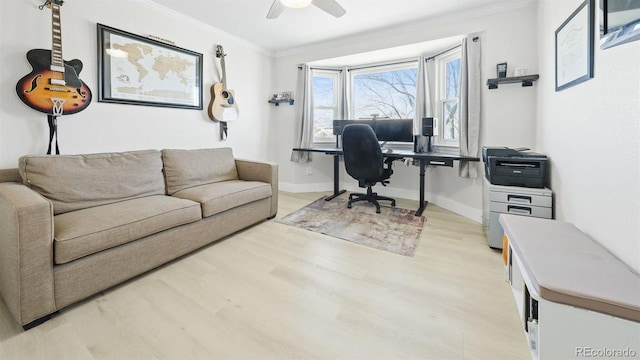 office space with light wood-style flooring, baseboards, crown molding, and ceiling fan