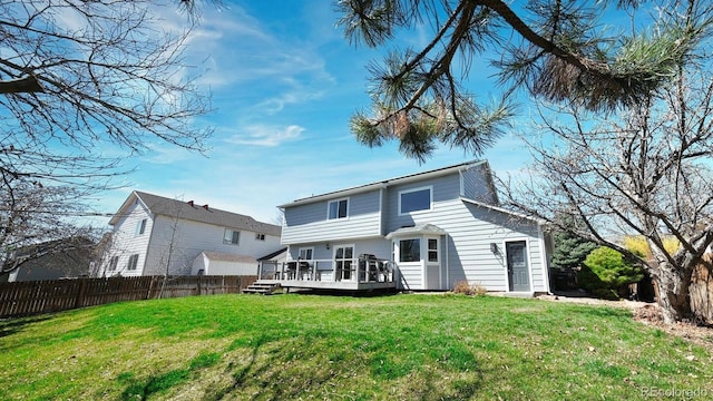 back of house with a deck, a yard, and fence