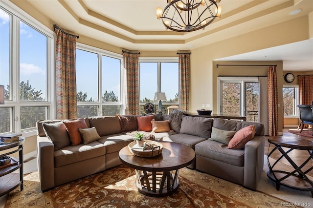 living room with a chandelier and a tray ceiling