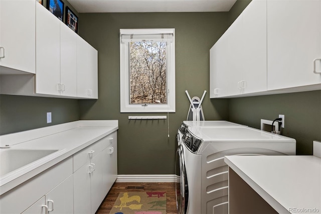 laundry room with dark wood-type flooring, cabinet space, baseboards, and separate washer and dryer