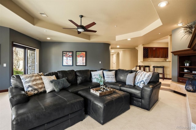 living room with visible vents, a tray ceiling, arched walkways, and recessed lighting