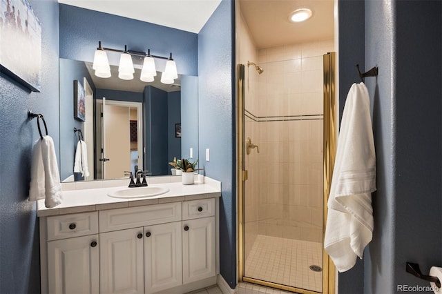 full bathroom featuring a textured wall, a shower stall, and vanity