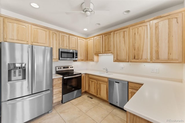 kitchen with appliances with stainless steel finishes, light brown cabinetry, sink, light tile patterned floors, and ceiling fan