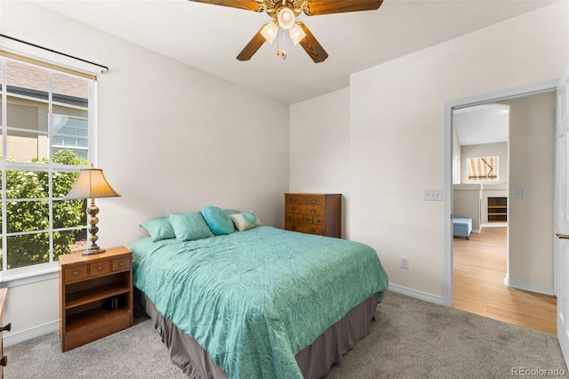 carpeted bedroom featuring multiple windows and ceiling fan