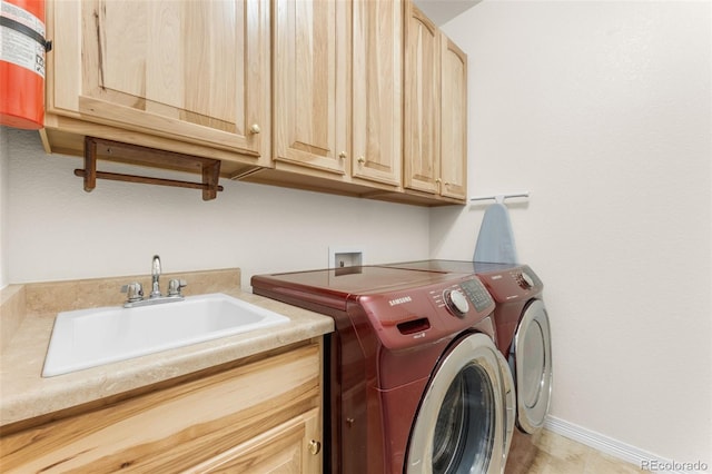 washroom featuring sink, cabinets, and washing machine and clothes dryer