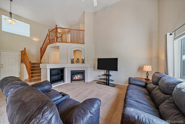 10723 W 54th Pl, Arvada, CO 80002 - carpeted living area featuring high vaulted ceiling, stairway, baseboards, and a tiled fireplace