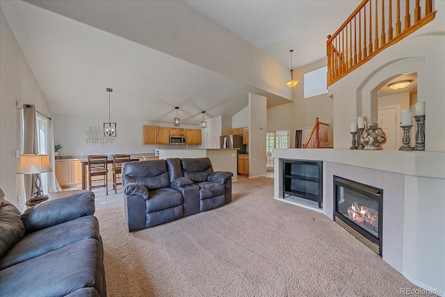 10723 W 54th Pl, Arvada, CO 80002 - living room with light carpet, a glass covered fireplace, high vaulted ceiling, and a chandelier