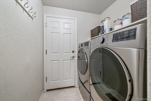 10723 W 54th Pl, Arvada, CO 80002 - laundry area with separate washer and dryer, light tile patterned floors, a textured wall, a textured ceiling, and baseboards