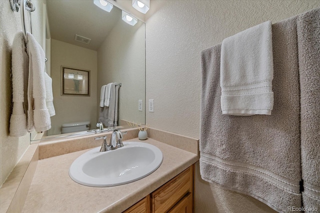 10723 W 54th Pl, Arvada, CO 80002 - half bathroom with a textured wall, vanity, and toilet