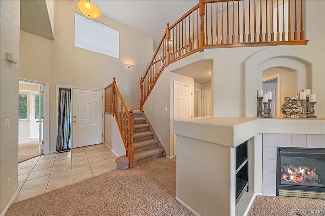 10723 W 54th Pl, Arvada, CO 80002 - entryway with carpet flooring, a towering ceiling, stairs, baseboards, and tile patterned flooring