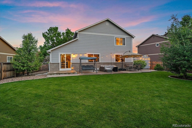 10723 W 54th Pl, Arvada, CO 80002 - back of property at dusk featuring a patio and an outdoor hangout area