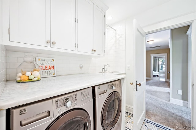 washroom with separate washer and dryer, sink, light colored carpet, and cabinets