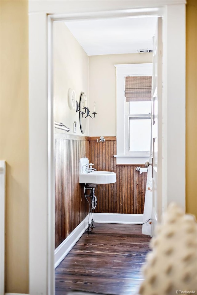 bathroom featuring hardwood / wood-style floors and wood walls