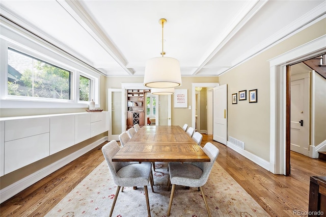 dining room featuring beam ceiling and light hardwood / wood-style floors