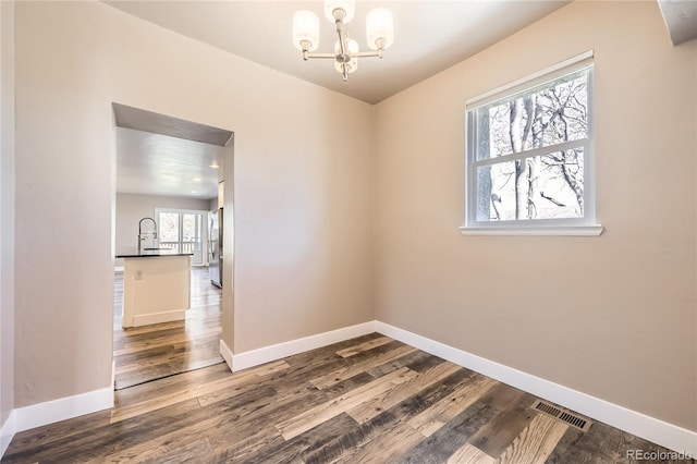 3225 Olive St, Denver, CO 80207 - spare room with a chandelier, wood finished floors, and baseboards