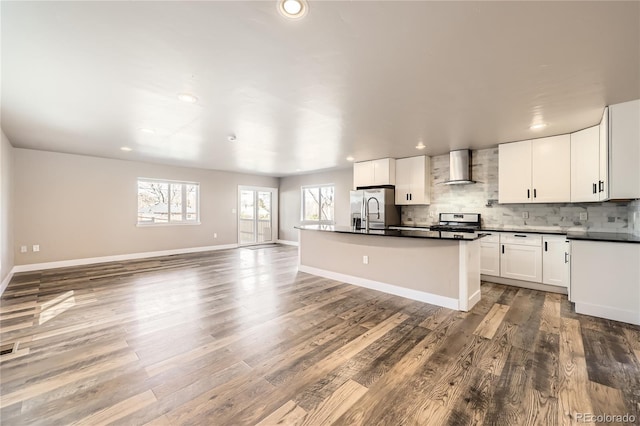 3225 Olive St, Denver, CO 80207 - kitchen with wall chimney exhaust hood, stainless steel appliances, healthy amount of natural light, dark countertops, and recessed lighting