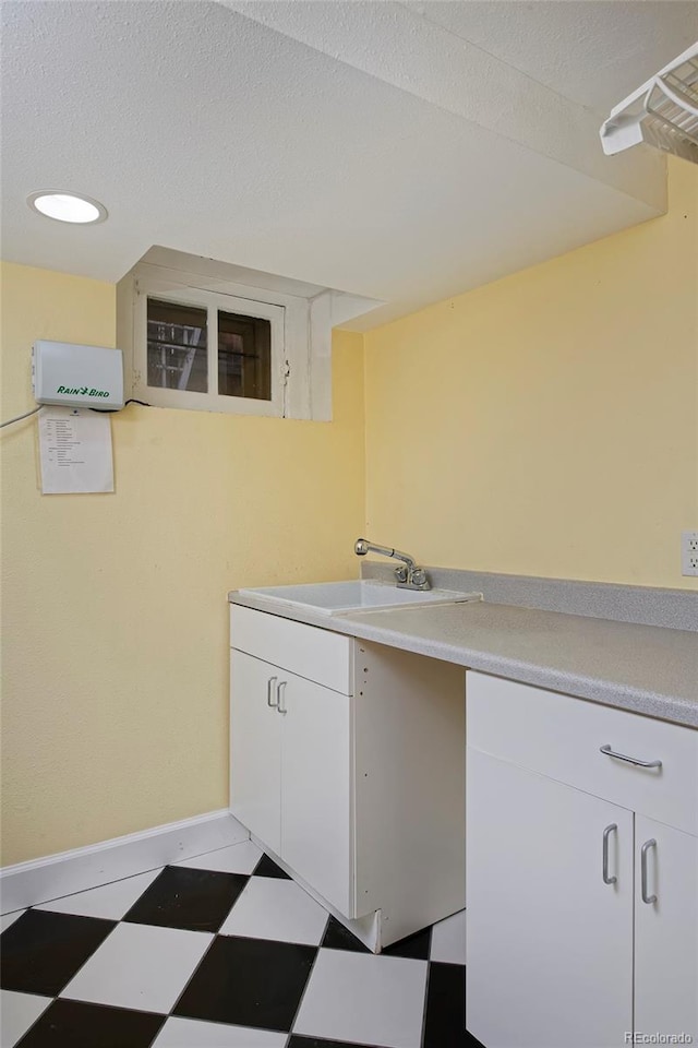 washroom with a textured ceiling and sink