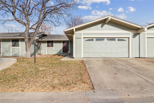 ranch-style home featuring an attached garage, concrete driveway, and a front lawn