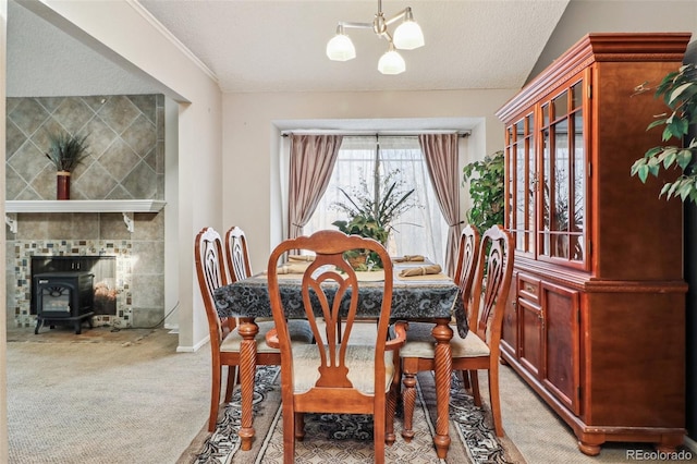 dining room featuring an inviting chandelier, a textured ceiling, a wood stove, and carpet