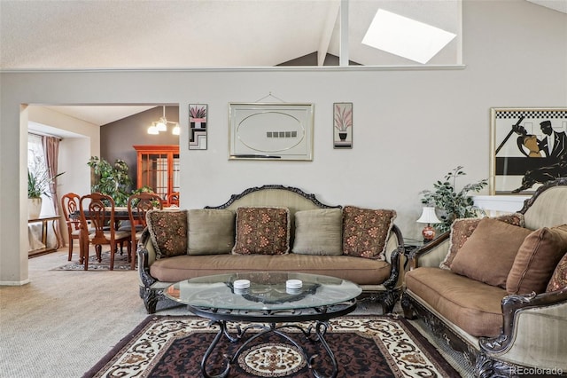 living room with vaulted ceiling with skylight and carpet