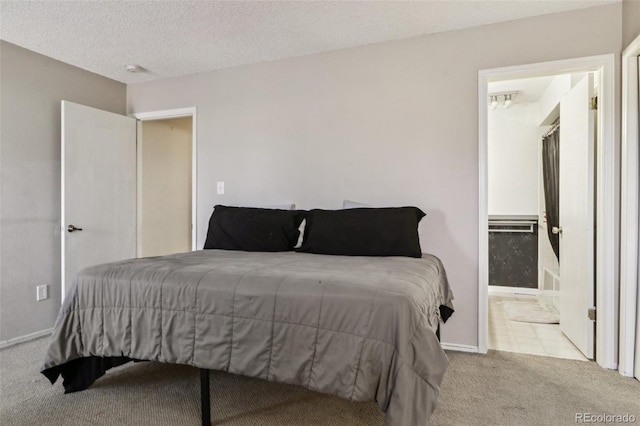 bedroom with connected bathroom, carpet floors, and a textured ceiling