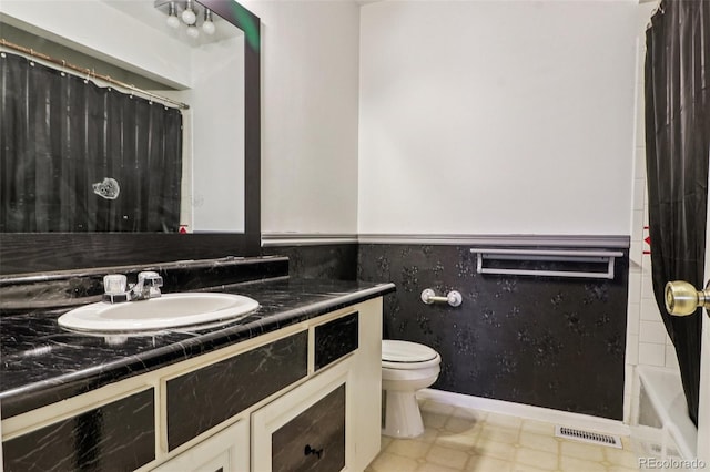 bathroom with vanity, visible vents, a wainscoted wall, tile patterned floors, and toilet