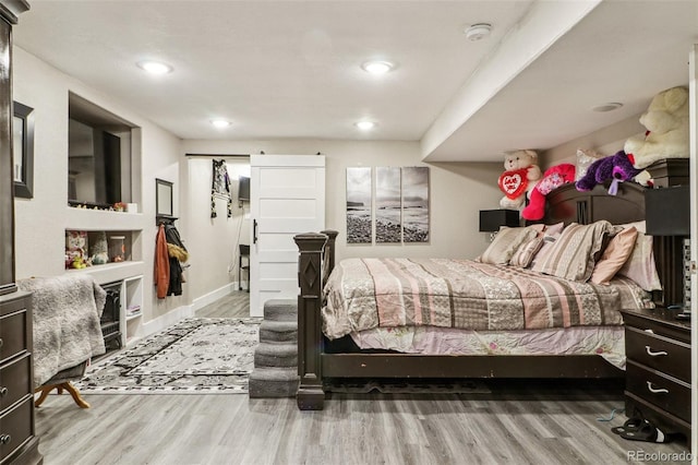 bedroom with recessed lighting, wood finished floors, and baseboards