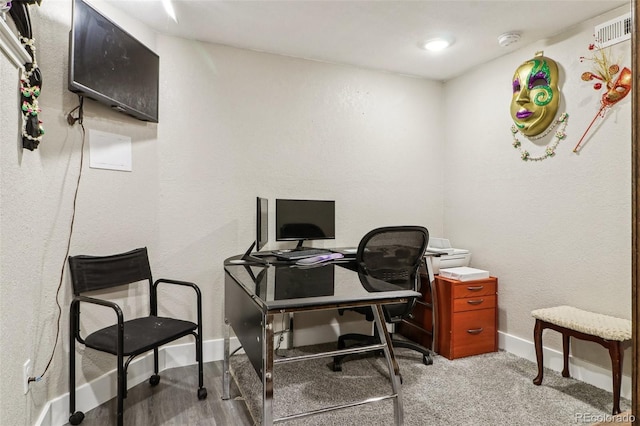 carpeted office featuring visible vents and baseboards