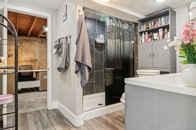 full bath featuring a stall shower, toilet, vanity, and wood finished floors