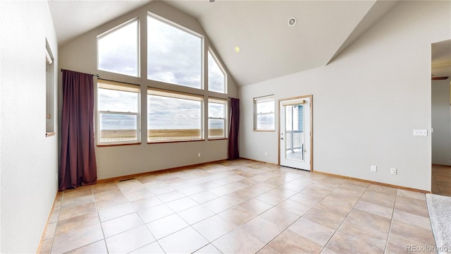 tiled spare room featuring high vaulted ceiling