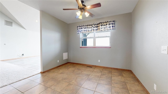 spare room with ceiling fan and light tile patterned floors