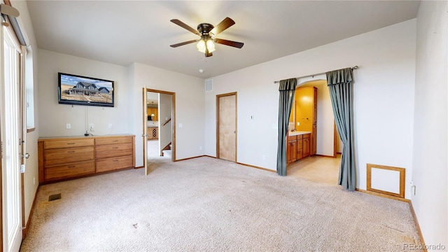 unfurnished bedroom featuring ceiling fan, connected bathroom, and light carpet