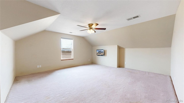 additional living space with ceiling fan, light colored carpet, and lofted ceiling