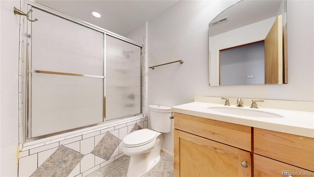 full bathroom featuring toilet, bath / shower combo with glass door, vanity, and tile patterned flooring