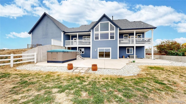 rear view of property with cooling unit, a patio, and a balcony