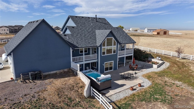 rear view of property with a sunroom, an outdoor living space, and a patio area