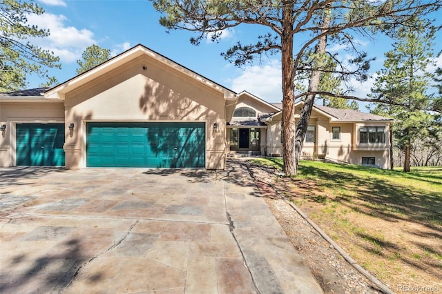 ranch-style house featuring stucco siding, an attached garage, driveway, and a front yard