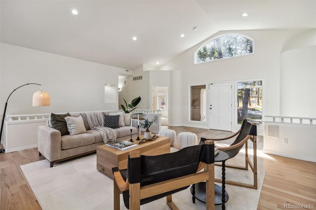 living room featuring light wood finished floors and high vaulted ceiling