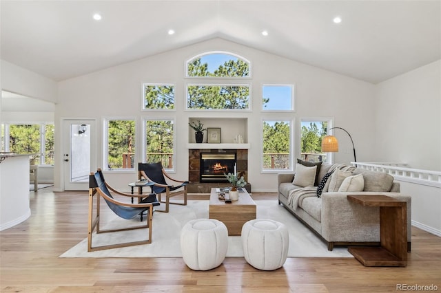 living room featuring a fireplace, light wood-type flooring, high vaulted ceiling, and recessed lighting