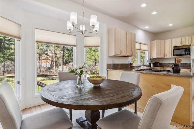 kitchen featuring light brown cabinetry, black microwave, recessed lighting, dark countertops, and a chandelier