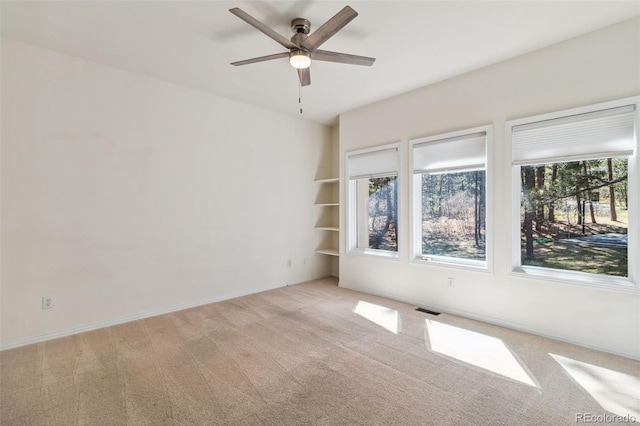 unfurnished room featuring light carpet, ceiling fan, and baseboards