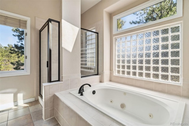 full bath featuring a stall shower, a jetted tub, and tile patterned floors