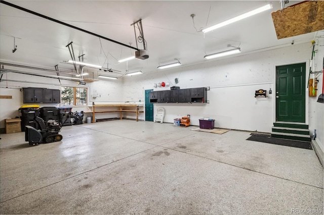 garage with a garage door opener and a workshop area