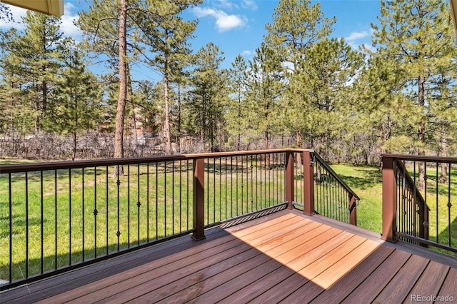 deck featuring a yard and view of wooded area